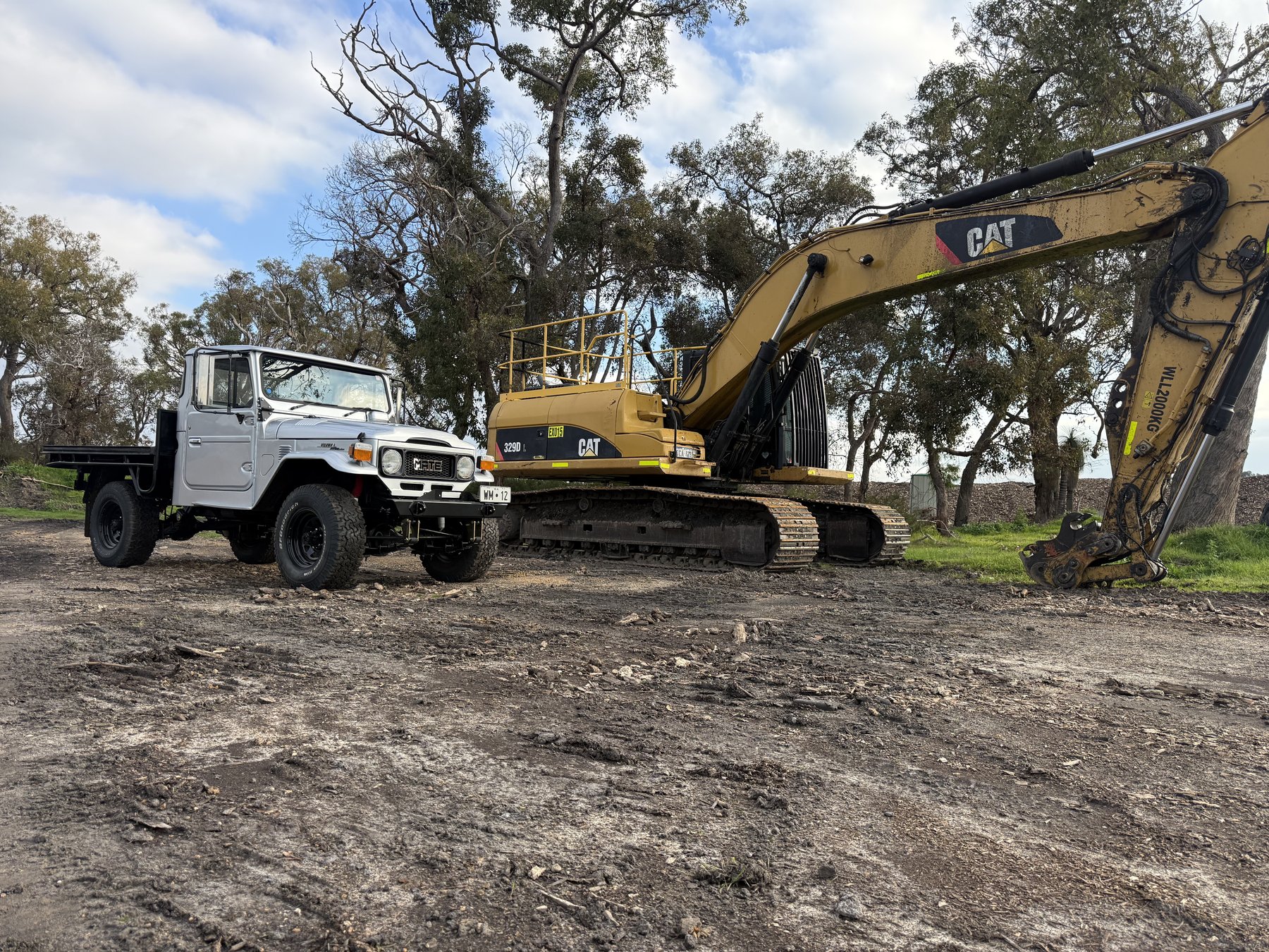 HJ47 parked next to a Cat 329D excavator